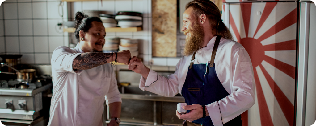 Two insured business owners giving each other a fist bump 

