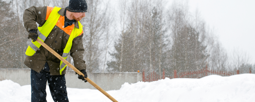 Man clearing snow with a shovel