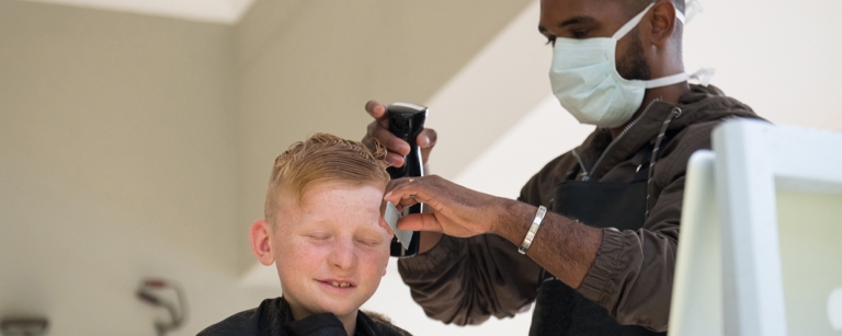 An insured mobile hairdresser cuts child’s hair
