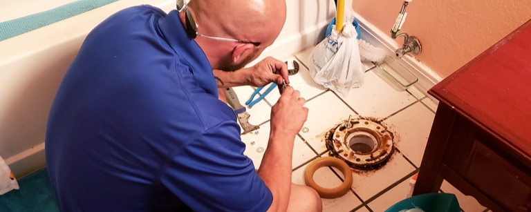A plumber with plumbing insurance installing a toilet