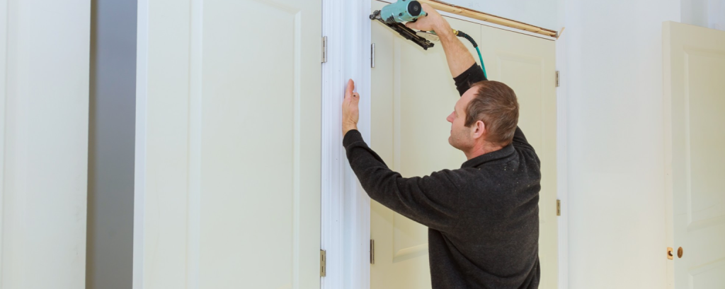 Contractor applies trim to doorframe