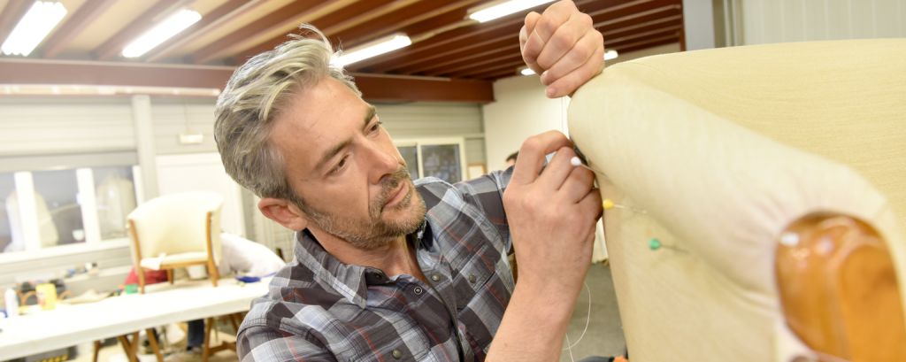 Upholsterer with a PA business insurance works on a chair

