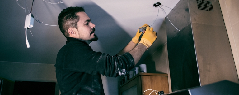 Electrician with electrician insurance is installing lighting