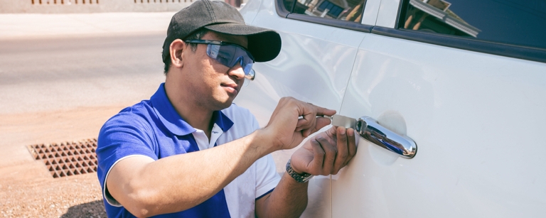 A locksmith opens a car door