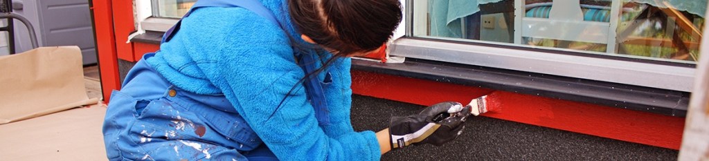 An insured painter is painting a window trim 