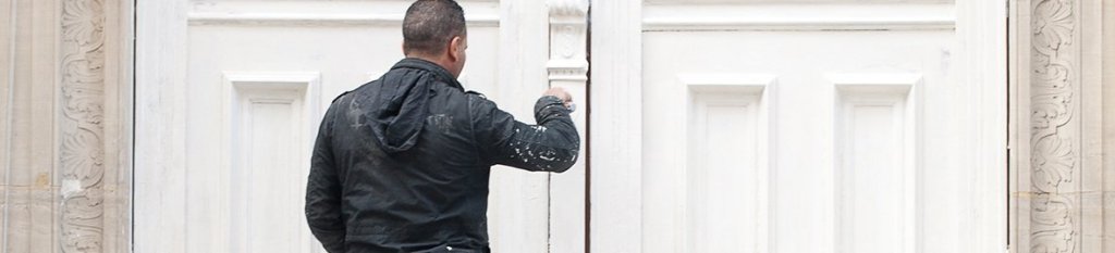 An insured painter is painting a door trim 

