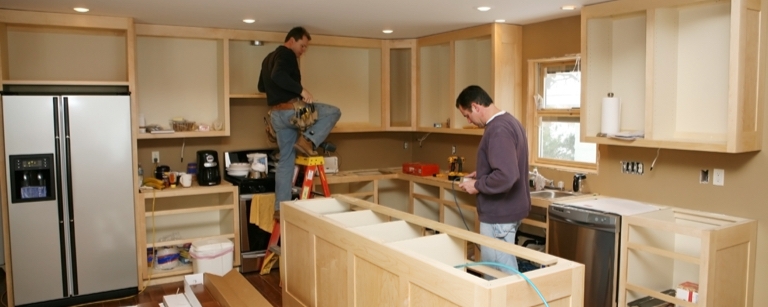 Subcontractors fitting a kitchen