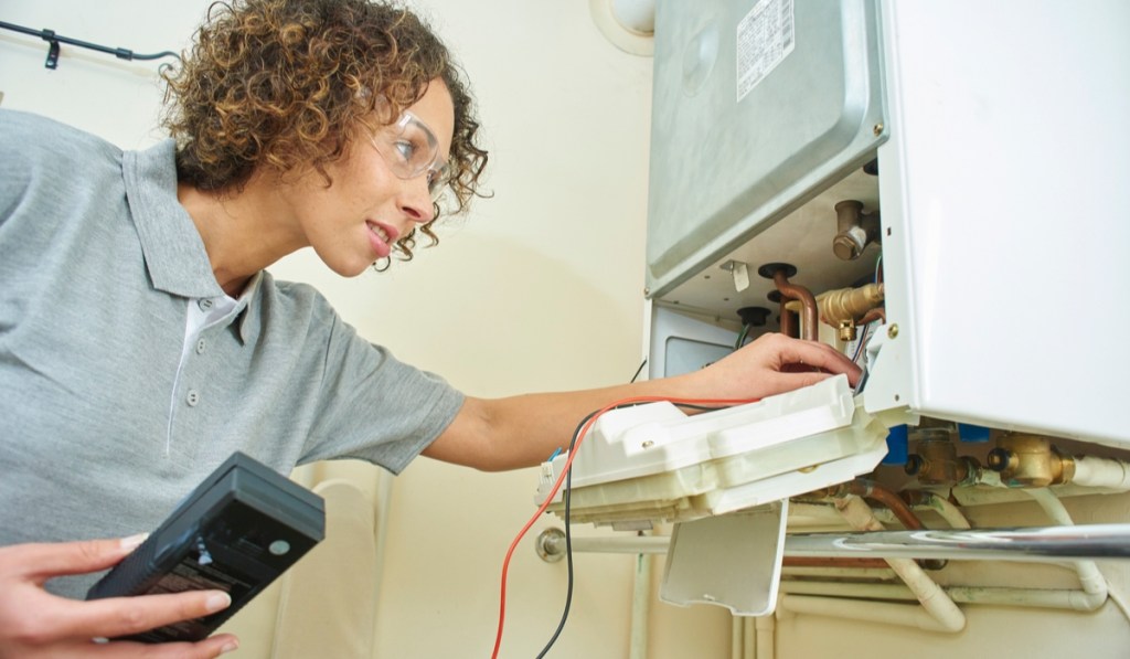 A woman with a Louisiana business license works on electric wiring.