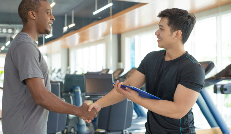 Two men shaking hands, one holding an iPad.