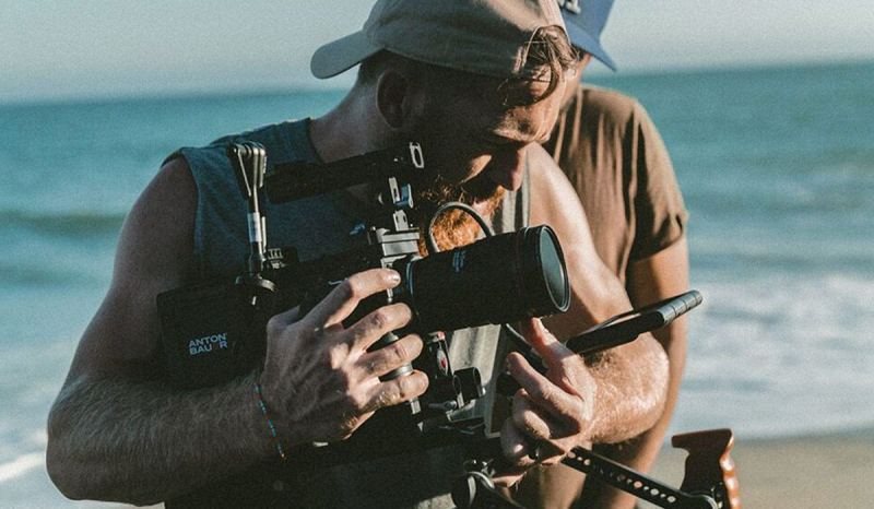 Learning how to become a professional photographer will keep you busy, like this photographer at a photo shoot.