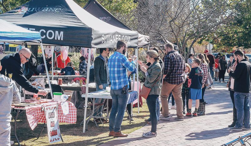 Business events near me: A man and a woman try food at a farmer's market