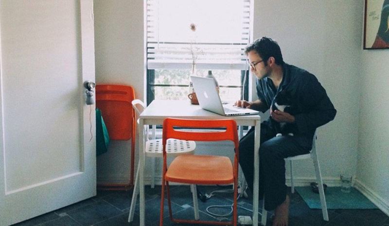 A man sits at a table while learning how to start a small business without money