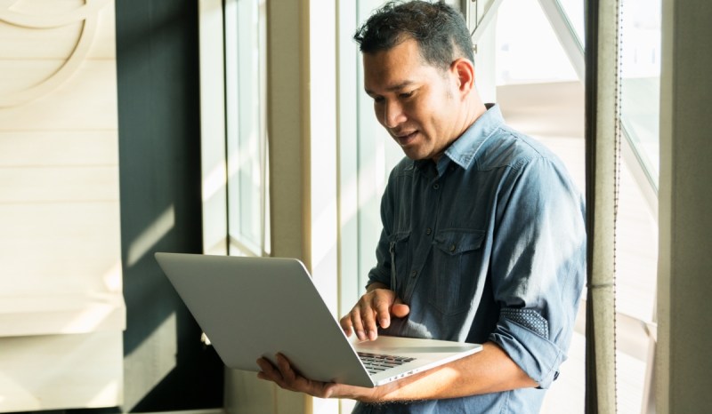 A man researches how to get a South Carolina business license on his laptop.