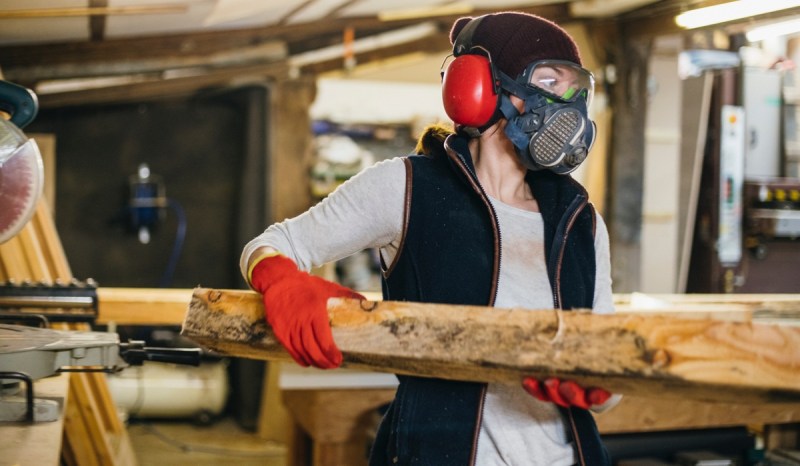 A carpenter with a Mississippi business license cuts wood.