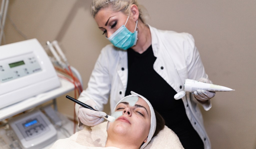 An esthetician with a Pennsylvania business license works on a client's face.