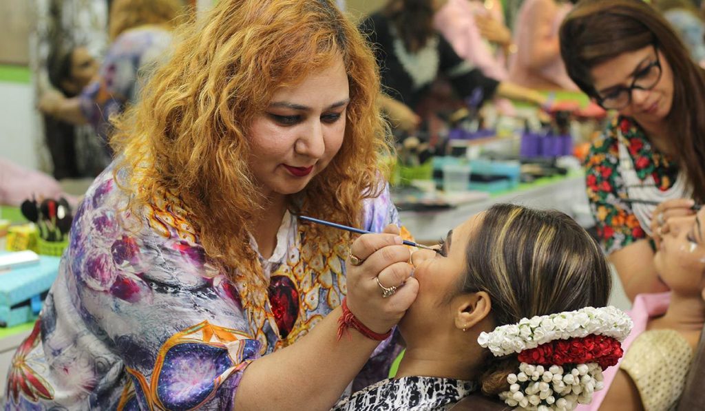 Business insurance can make it easier to get customers, like this makeup artist working on a client.