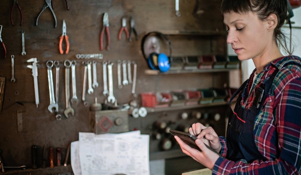 A woman in a workshop at her smart phone