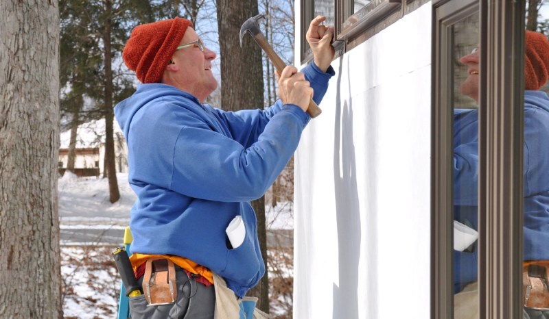 A contractor with a Montana business license repairs a window.