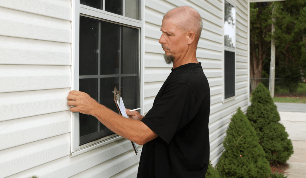 An insured, bonded and licensed contractor inspecting client’s windows