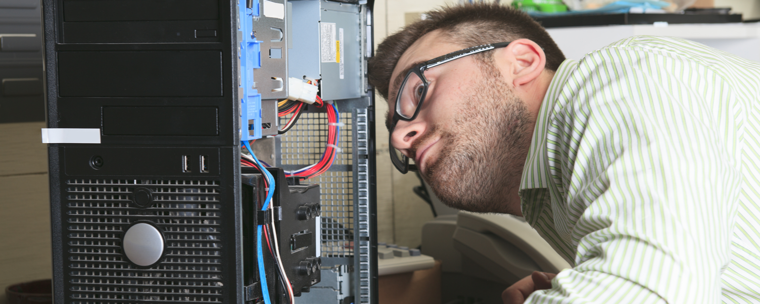 IT Technician with a NY business insurance inspects a computer