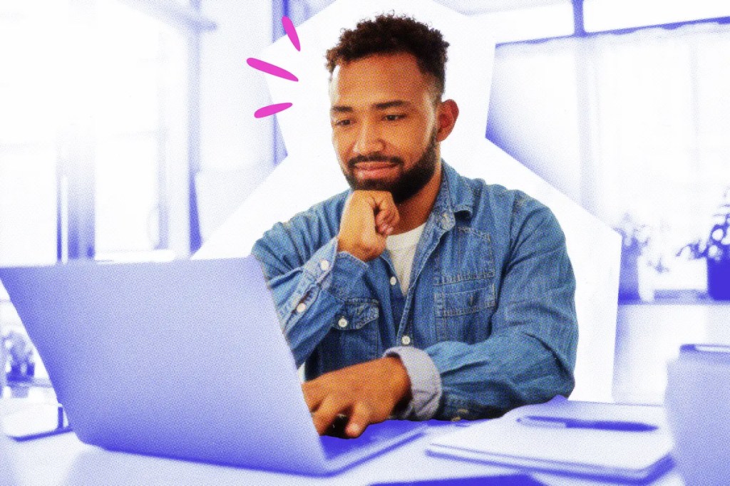 Designer at a table working on a laptop