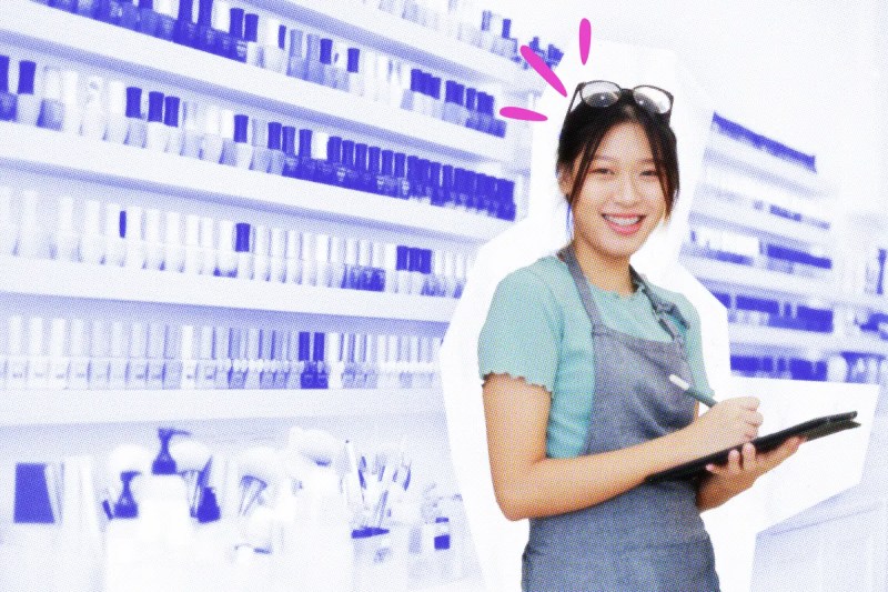 Nail tech with a tablet standing in front of shelves of nail polish.