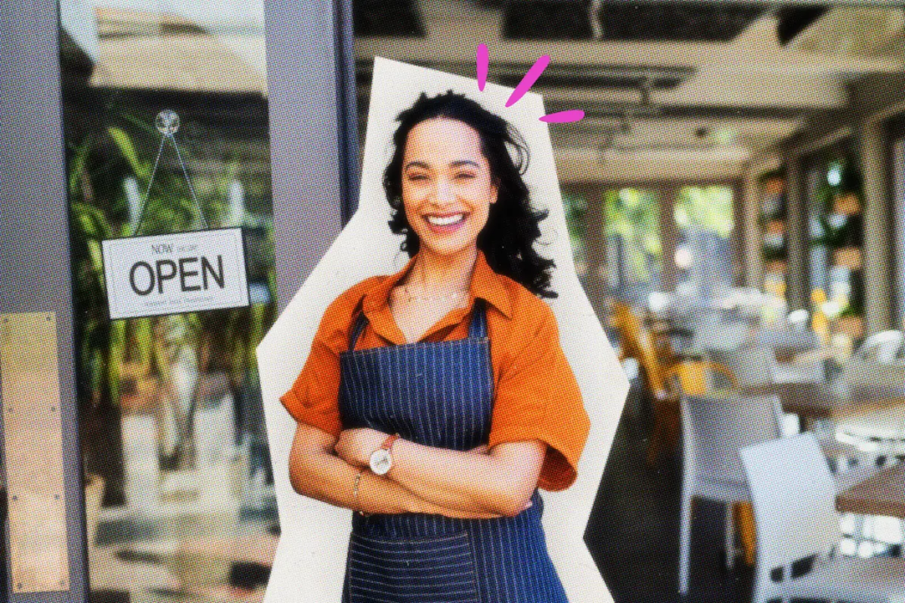 Smiling shop owner standing in front of her new business.