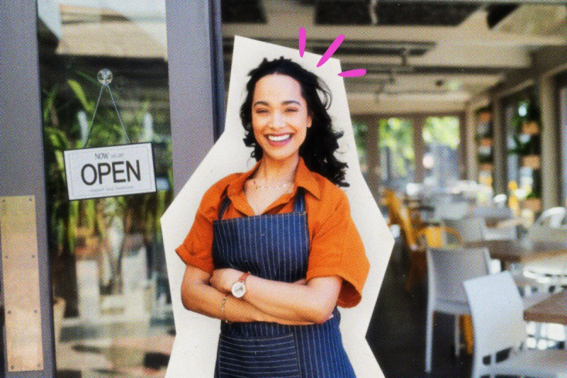 Smiling shop owner standing in front of her new business.