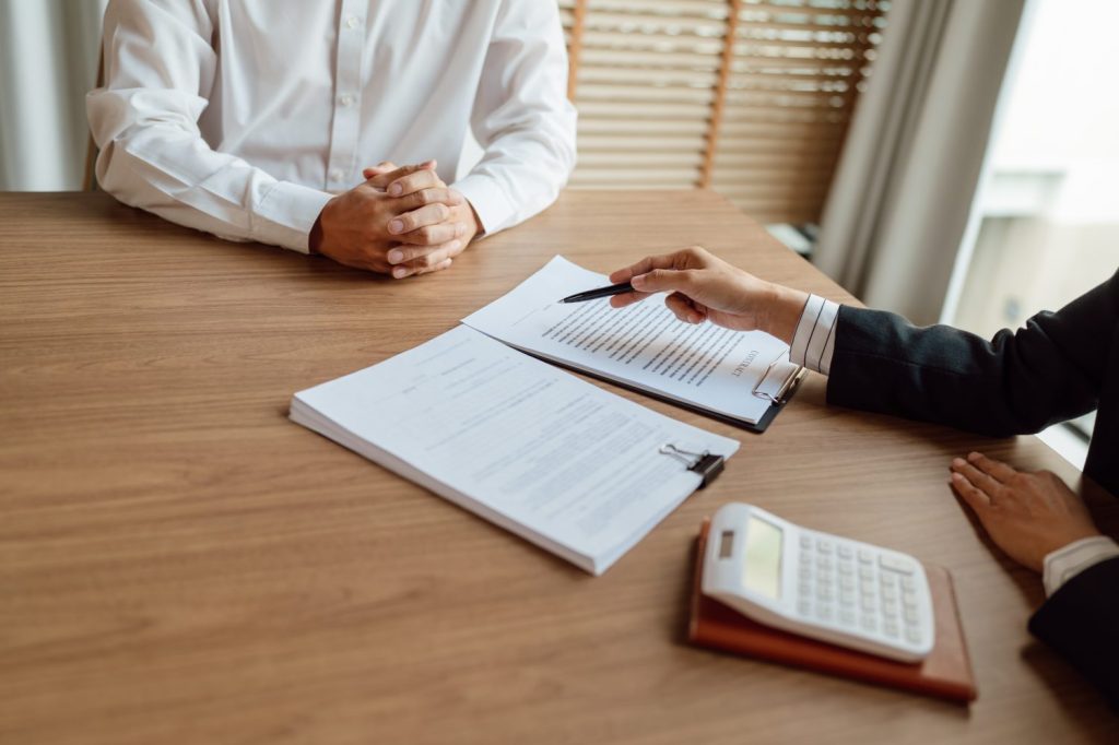 Business professional reviewing insurance documents with client