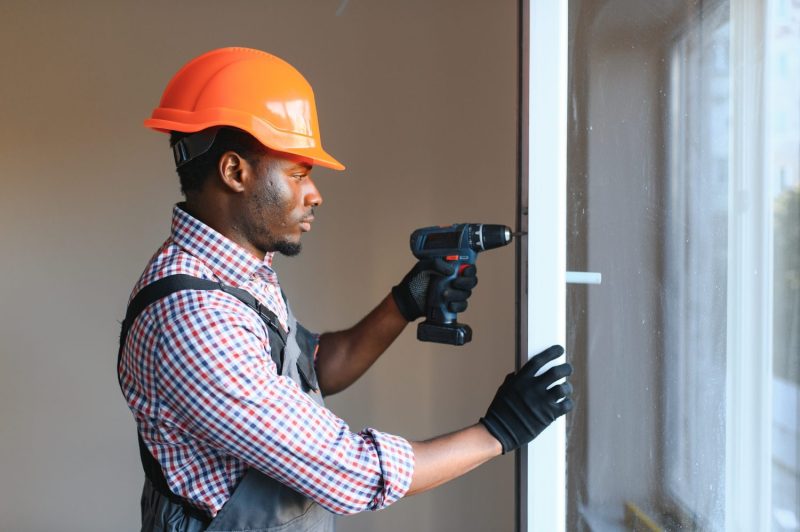 Handyperson drilling a doorframe